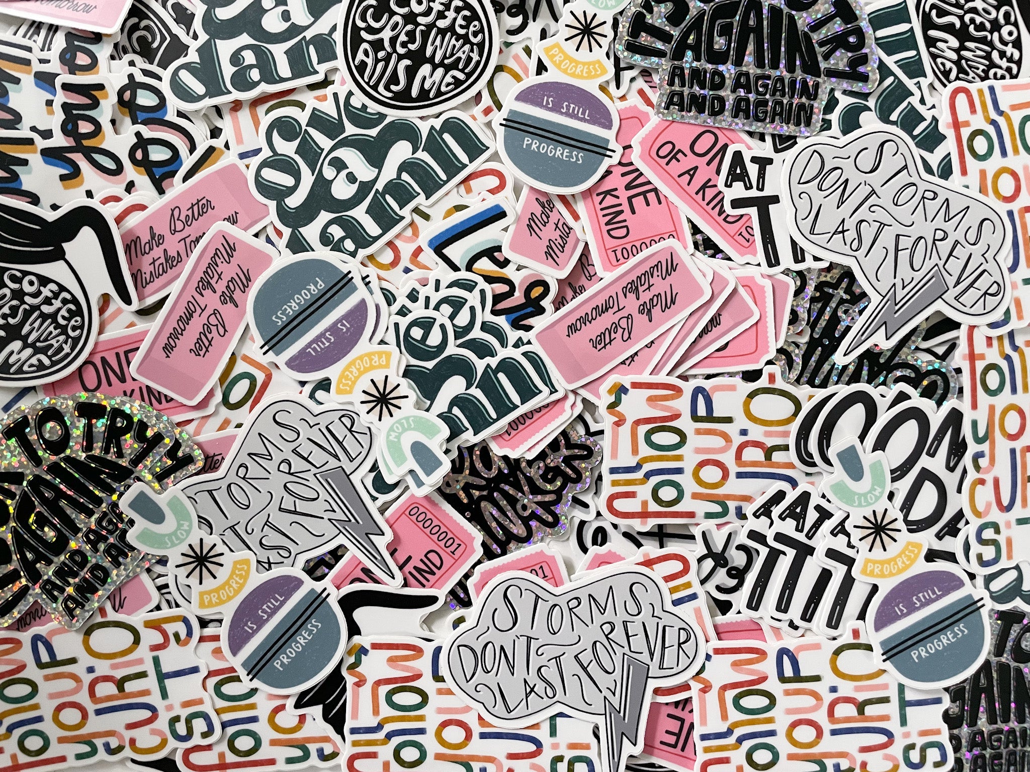 Collection of colorful stickers with motivational phrases on a patterned background