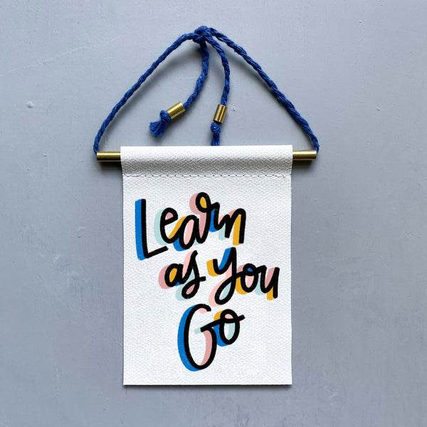 Learn As You Go Brass and String Hanging Banner